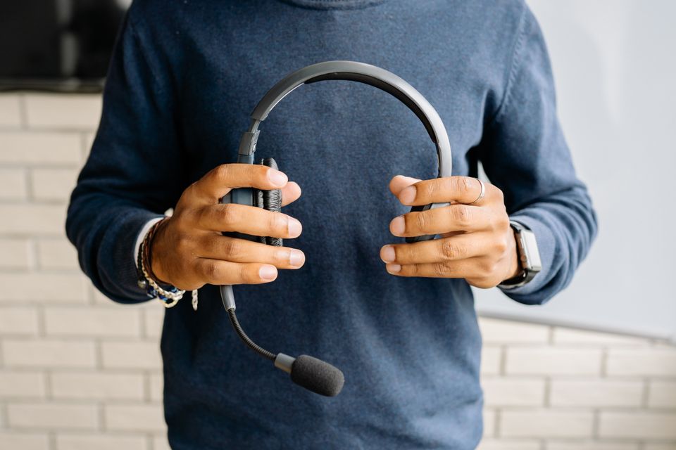 Hands holding an IT support headset